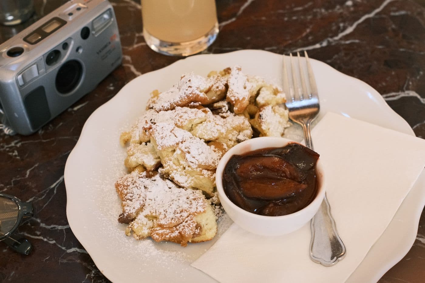 A tasty plate of Kaiserschmarrn with plum compote on a cafe table in Vienna.